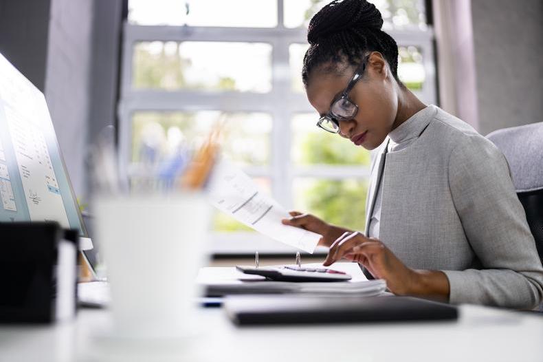 Woman looking at paperwork and calculator.jpg