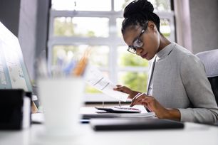 Woman looking at paperwork and calculator.jpg